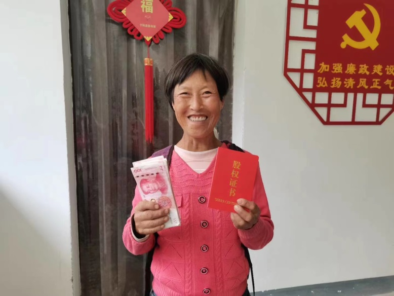 2019年9月，村民吴汉秀收到东胜生态养殖合作社的第一次分红。图片来源：北京银行