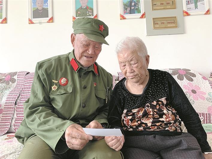 老军垦马福元（左）和妻子在翻看以前的照片（资料图片）。谢增杰 摄