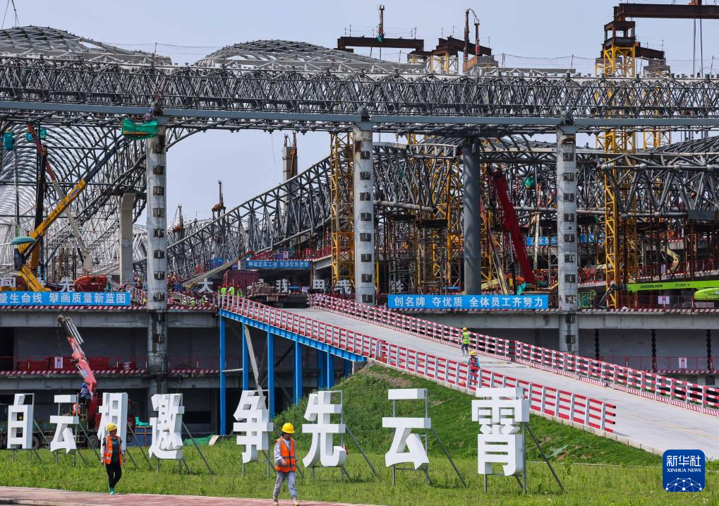 4月26日，建设者经过建设中的广州白云机场T3航站楼。新华社记者 刘大伟 摄