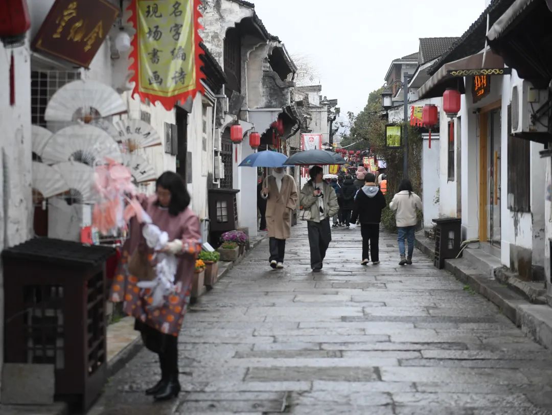 人们在细雨中游览绍兴仓桥直街。翁忻旸摄（新华社）