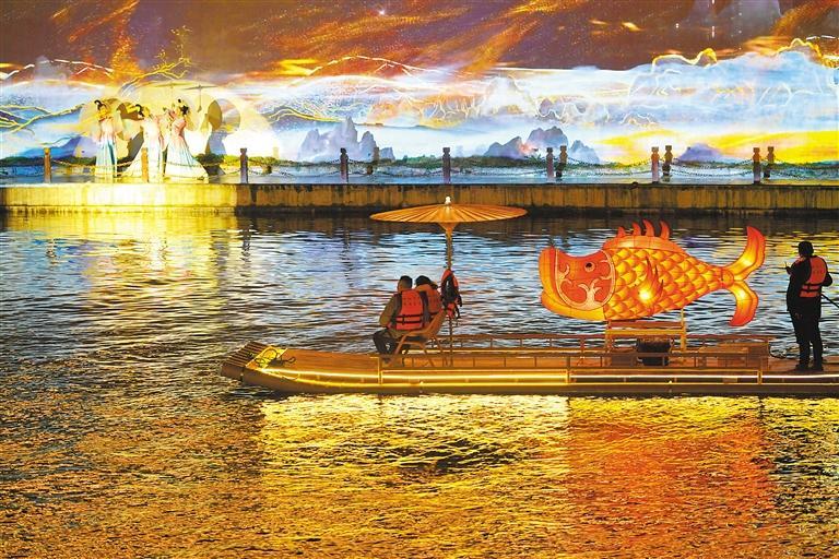 图为游客乘坐竹筏在湖北省宣恩县贡水河上观看河岸实景歌舞表演（2024年2月20日摄）。新华社发