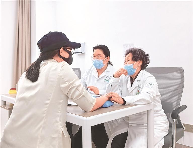 国医大师何成瑶（右一）正在把脉问诊。 贵州日报天眼新闻记者 胡家林 摄