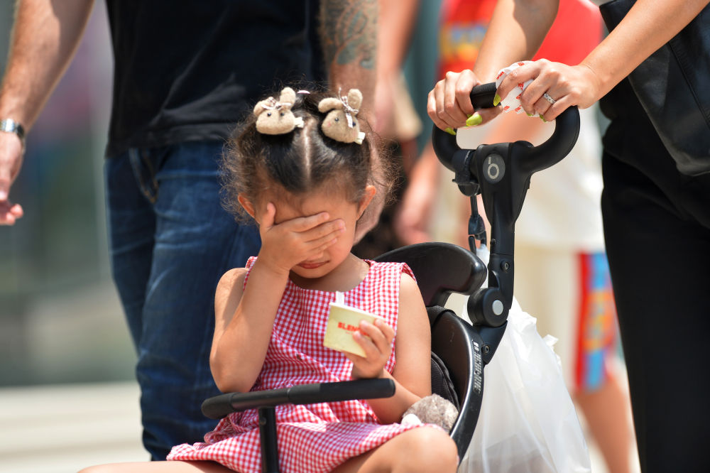 4月3日，一名儿童在泰国曼谷街头用手遮阳。新华社发（拉亨摄）