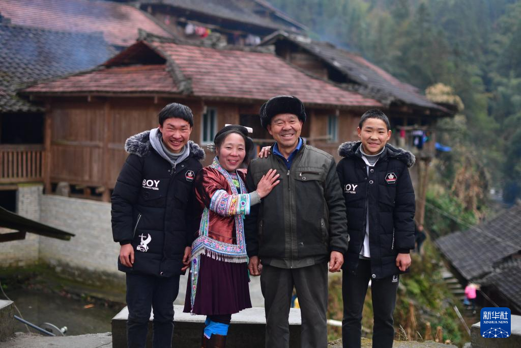   在乌英苗寨，梁足英（左二）和丈夫、儿子合影（2019年2月13日摄）。 新华社记者 黄孝邦 摄