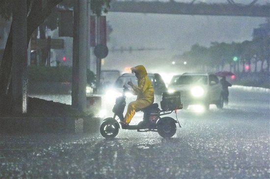 27日下午5时许，广州市雷雨大作，白昼如夜。珠江新城花城大道路段，外卖小哥冒着暴雨坚持送餐    羊城晚报记者 周巍 摄