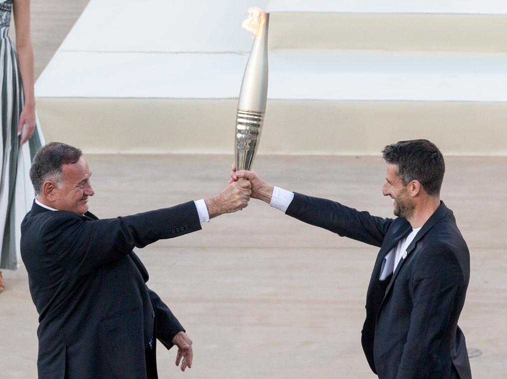 4月26日，希腊奥委会主席卡普拉洛斯（左）将火炬交给巴黎奥组委主席埃斯坦盖。新华社发（马里奥斯·罗洛斯摄）