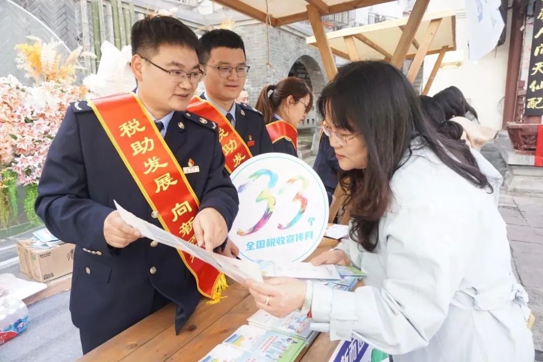 在安庆古城倒扒狮历史文化街区，税务干部宣传个人所得税相关政策。