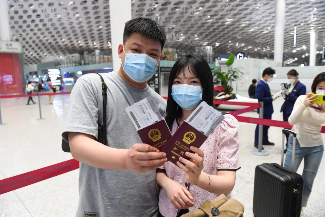 2023年2月12日凌晨，在中国深圳，即将搭乘印尼狮航包机前往巴厘岛旅游的游客夫妇拿着护照和登机牌合影。