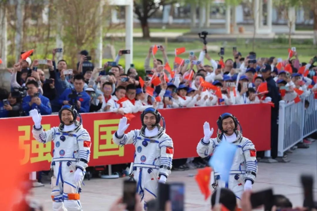 队员们挥舞着国旗，欢送三位航天员出征  朱雪超 摄
