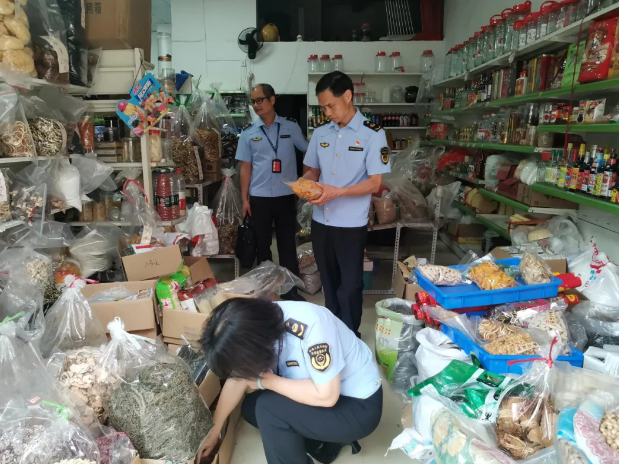 武江区市场监管局执法人员对受淹食品经营户在售食品进行逐一检查。