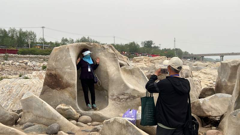 游客在巨石滩景观处打卡拍照。新京报记者 陈璐 摄