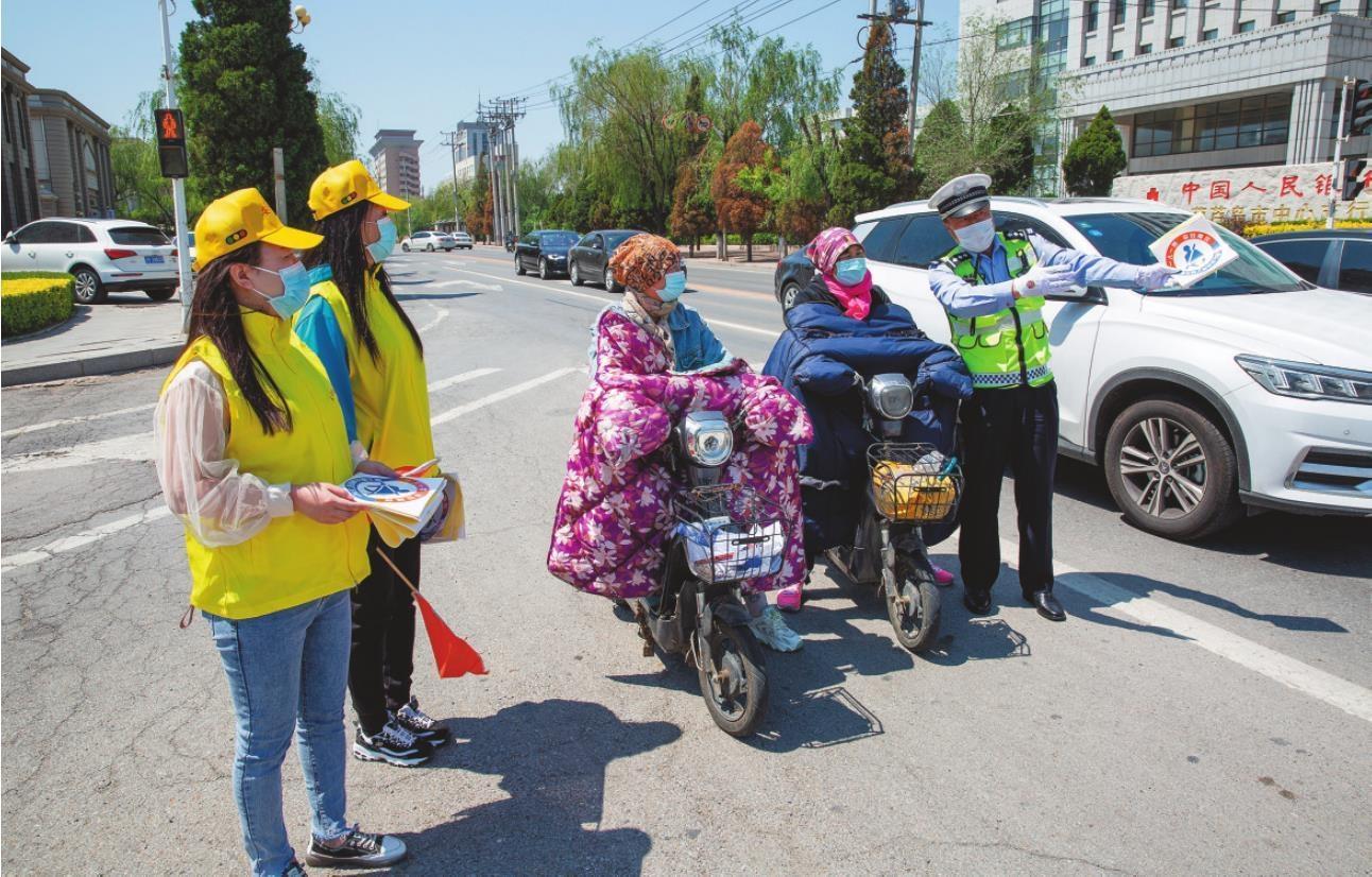 志愿者配合交警在路上开展交通文明引导。刘　　水　　摄