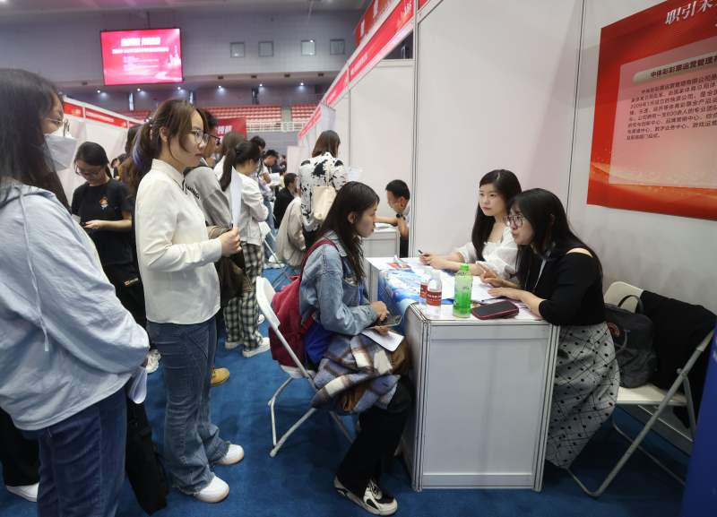 毕业生与企业工作人员进行交流。新京报记者 王贵彬 摄