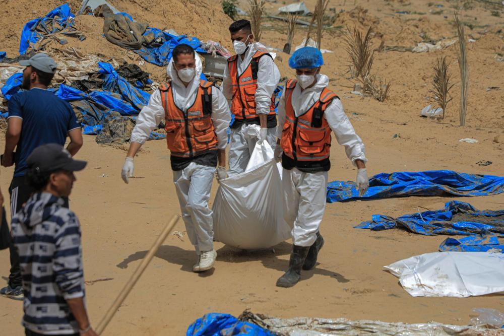 4月23日，工作人员在加沙地带南部城市汗尤尼斯的纳赛尔医疗中心转移尸体。图片来源：新华社