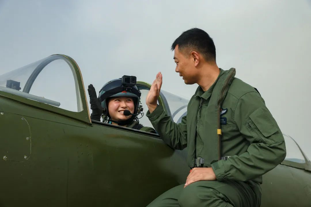 2024年4月25日，我国首批舰载机女飞行学员首次单飞。这是飞行学员（左）同飞行教官击掌。（于涛 摄）