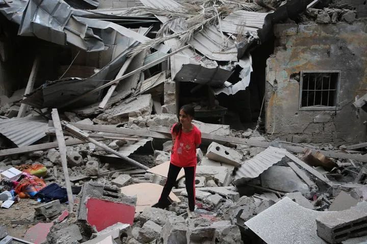 4月27日，在加沙地带南部城市拉法，一名女孩站在以军空袭后的废墟上。新华社发（哈立德·奥马尔摄）