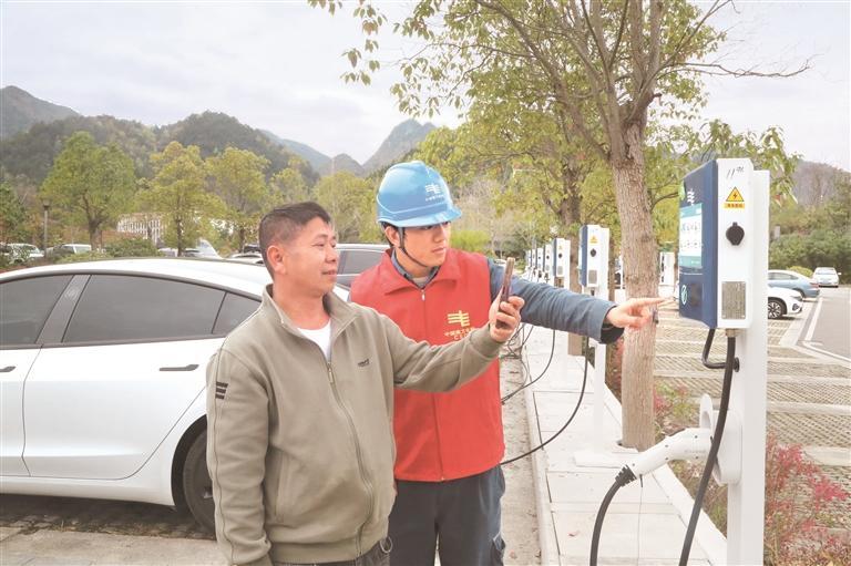 荔波供电局服务队队员在小七孔景区东门停车场指导游客使用充电桩。 王文涛 摄