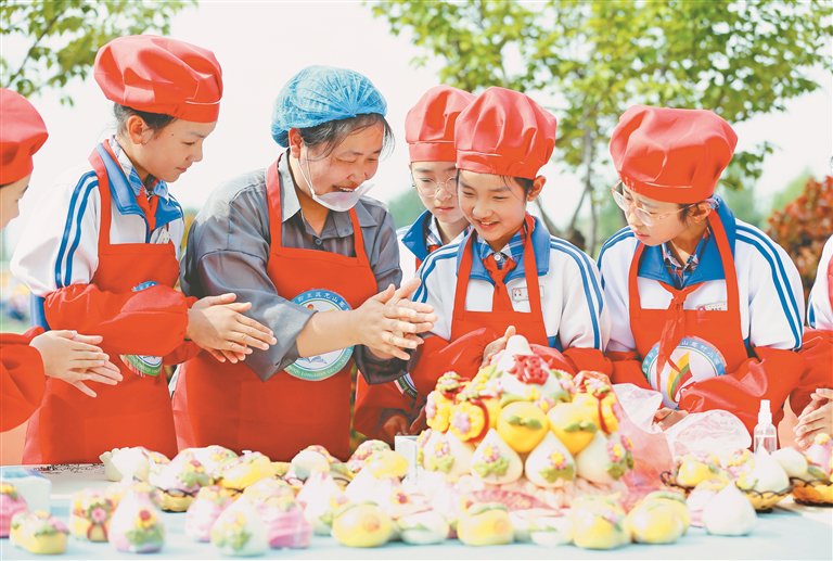 4月28日，山东省青岛市即墨区龙山葛村小学的学生在老师的指导下学习做花馍。