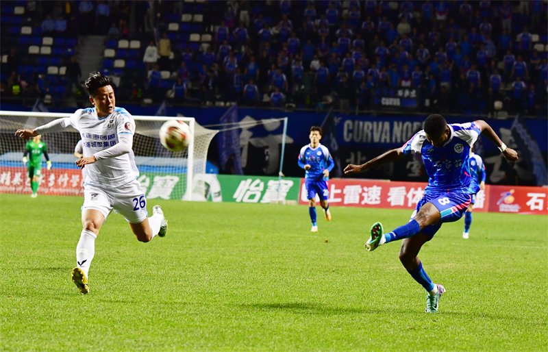4月28日，石家庄功夫队球员阿约维（右一）在比赛中射门。新华社发（张晓峰摄）