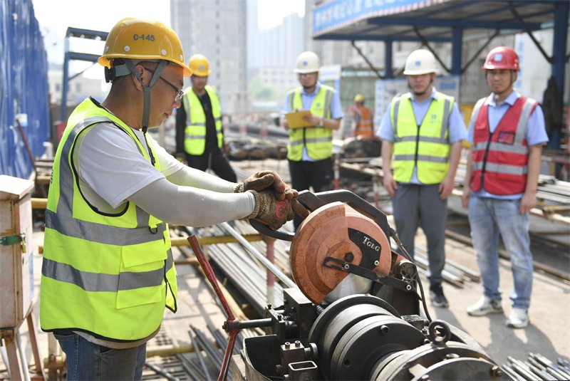 4月27日，在中建二局北方公司河北邯郸汉光悦府项目建设现场，建筑工人参加钢筋切割比赛。新华社发（胡清华摄）