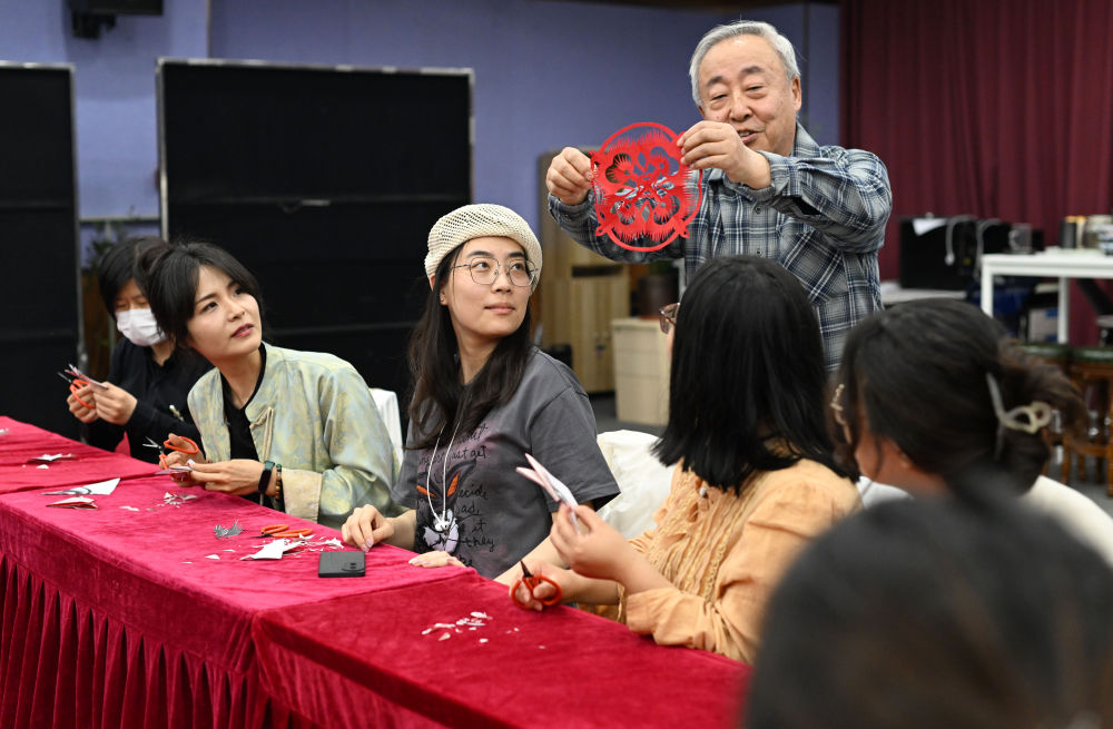↑4月24日，在天津市河西区春秋文化艺术中心，河西区青年夜校教师在剪纸体验课上展示学员作品。