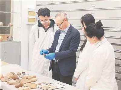 王伟（左二）在指导学生观察石器。受访者供图