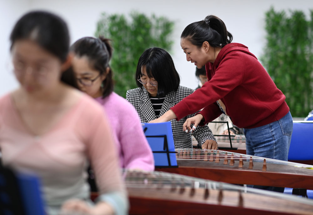 ↑4月23日，在天津青年宫，青年夜校教师刘冰指导学员学习古筝。