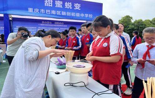 4月26日，龙洲湾中学学生在重庆市巴南区融创初级中学展区体验棉花糖制作。谭权洁/摄