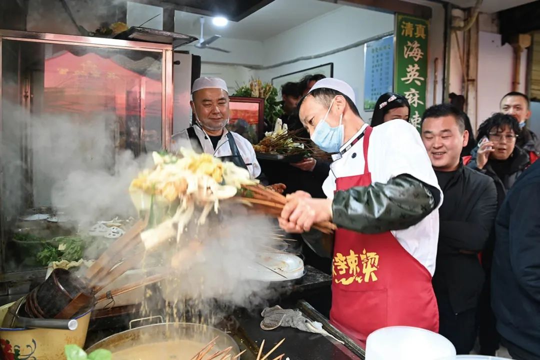 上图：在天水市秦州区的天水名优小吃城一麻辣烫店，商家为游客加工麻辣烫。