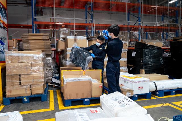 浦东机场海关跨境电商监管作业现场，海关关员正在对退货商品进行仔细查验。（何逸青 摄）