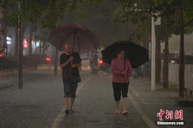 资料图：广东省广州市受强雷雨云团影响，出现强雷雨天气，图为市民雨中出行。中新社记者 陈骥旻 摄