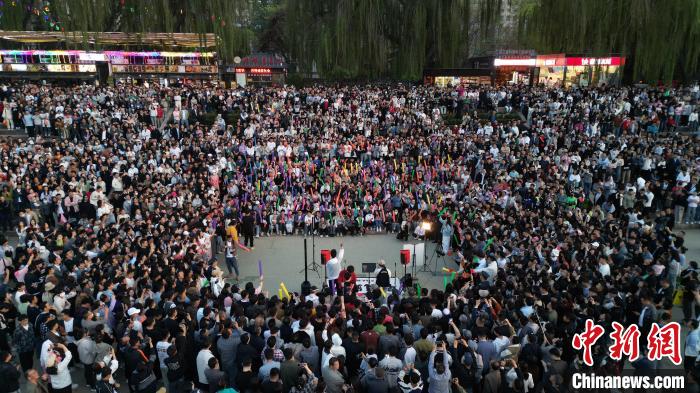 4月23日晚，甘肃兰州，在黄河畔举行的路边演唱会吸引了民众前来“打卡”。图为民众在黄河边合唱。(无人机照片) 九美旦增 摄