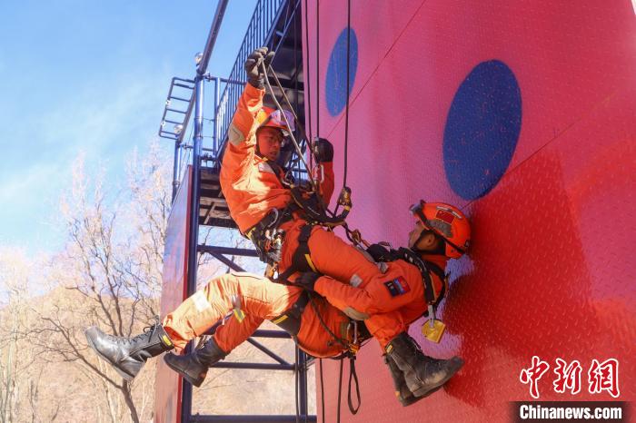 比赛现场，消防员运用一对一挂接救援技术将被困者安全下放至地面。姚天锐 摄