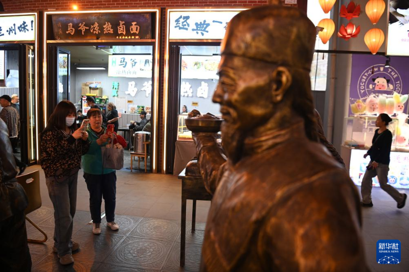 4月26日,游客在位于兰州市城关区的黄河食渡文旅美食街游览拍照.