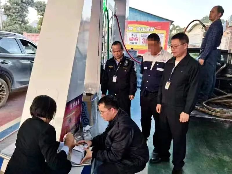 图为来宾市市场监管局执法人员在加油站对成品油进行抽样，确保质量安全。