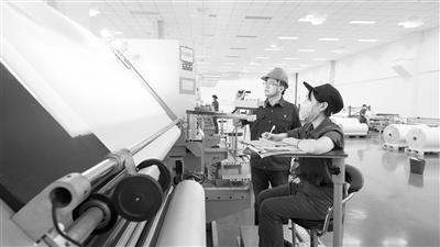 泰山玻纤超薄布车间技术人员正在进行新产品研发与试验。中国建材供图