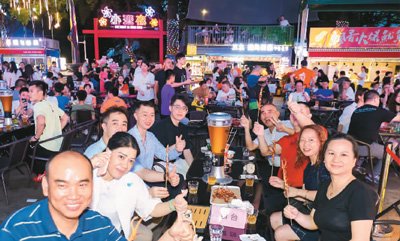 图为顾客在深圳盐田沙头角的“小港夜”夜市用餐、留影。