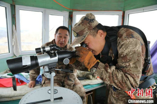 图为杨卫东(左一)在教朱晓龙使用瞭望仪器。赵兴祖 摄