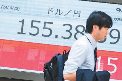 　　行人走过日本东京一处显示实时汇率的电子屏幕。新华社记者 张笑宇摄