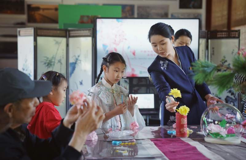 5月2日，中国园林博物馆，一位科普老师在给小朋友讲解牡丹花创意捏塑技巧。新京报记者 薛珺 摄