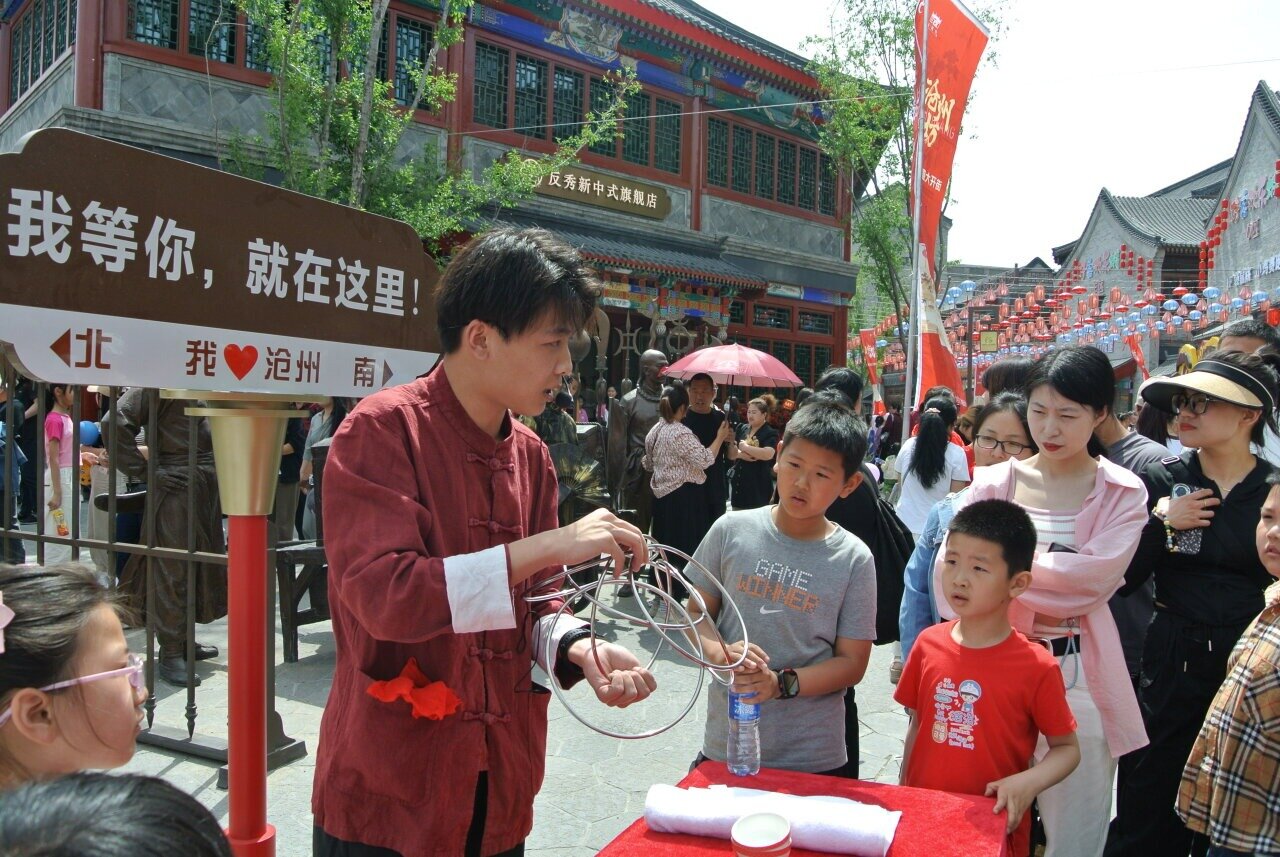 5月1日，在沧州坊商街，来自吴桥杂技大世界的表演者刘佳泽在表演魔术。  河北日报记者 王雅楠摄