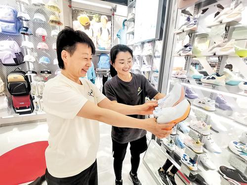5月1日，在廊坊市明珠大厦运动休闲馆的李宁YOUNG专卖店，市民正在选购运动鞋。河北日报记者 刘杰摄