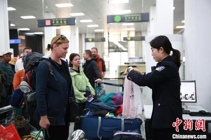 图为“五一”假期，民警王靖正在检查出境旅客的行李物品。肖富贵摄
