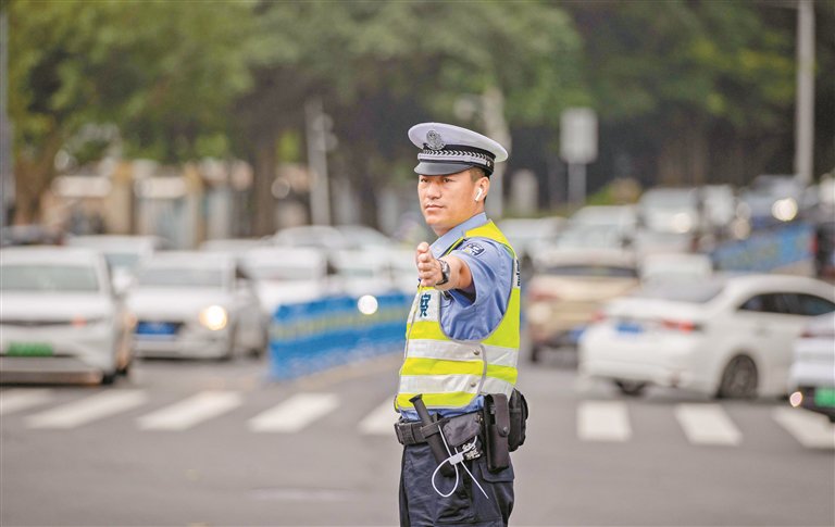 盐田交警大队梅沙中队黄栋中队长在指挥交通.深圳特区报记者 赖犁 摄