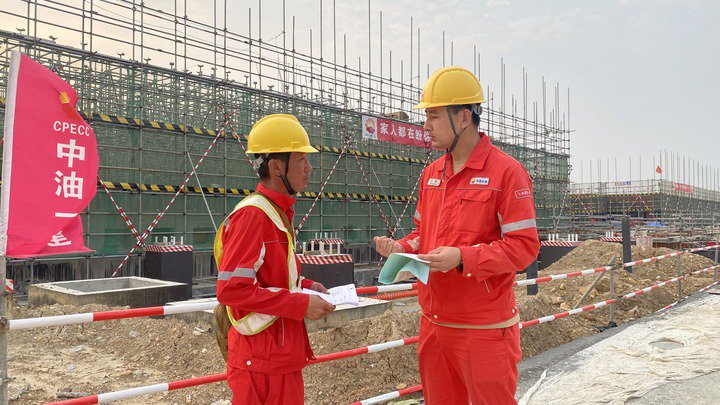 中国石油工程建设有限公司第一建设公司广西项目副经理武鹤（右）在广西石化炼化一体化转型升级项目施工现场。（采访单位供图）