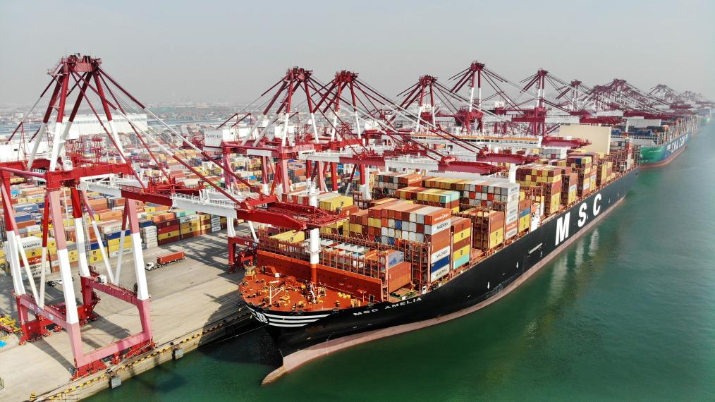 　　3月13日，货轮在山东港口青岛港装卸集装箱（无人机照片）。新华社记者李紫恒 摄