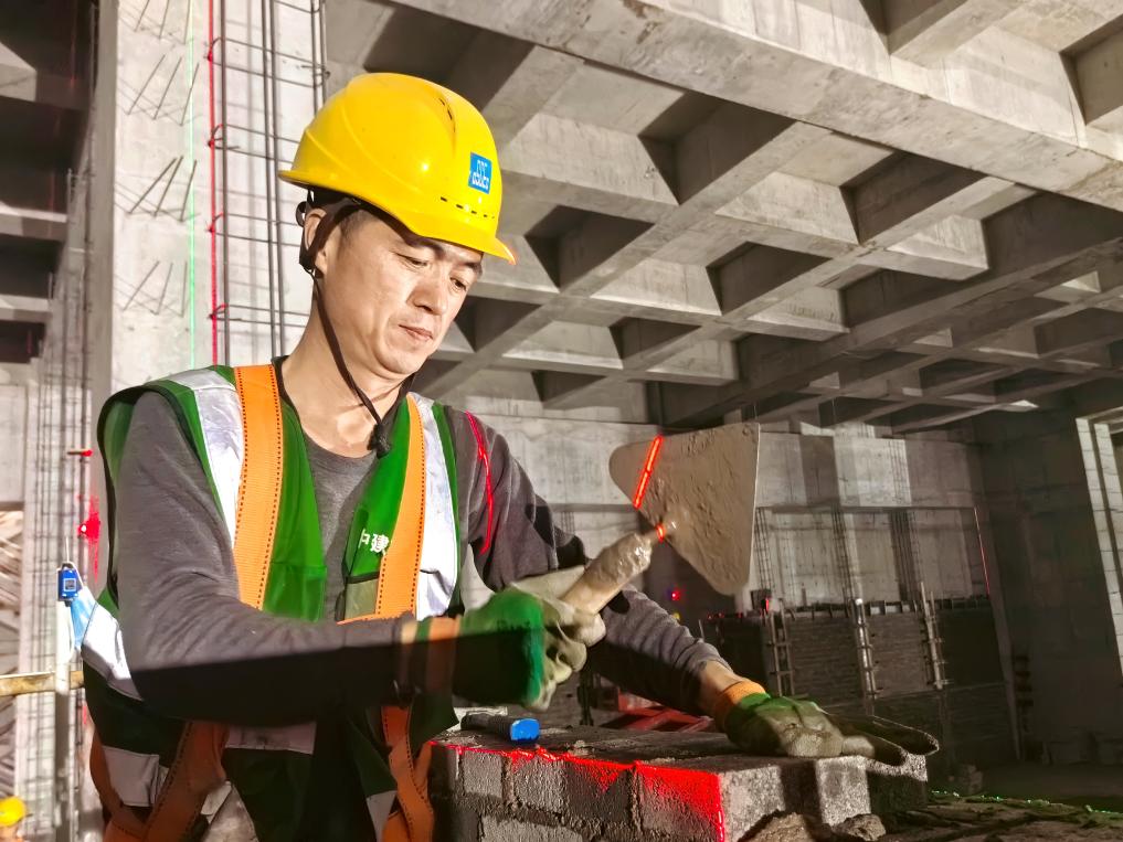 2024年“五一”假期，砌筑工纪庆生在北京东南高速公路智慧物流港的工地上忙碌。（中建三局供图）