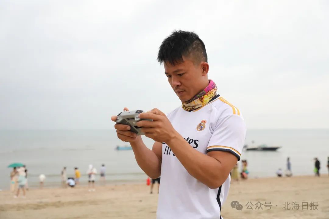 叶维法在操作无人机拍摄紫霞湾景色。方晓淦 摄