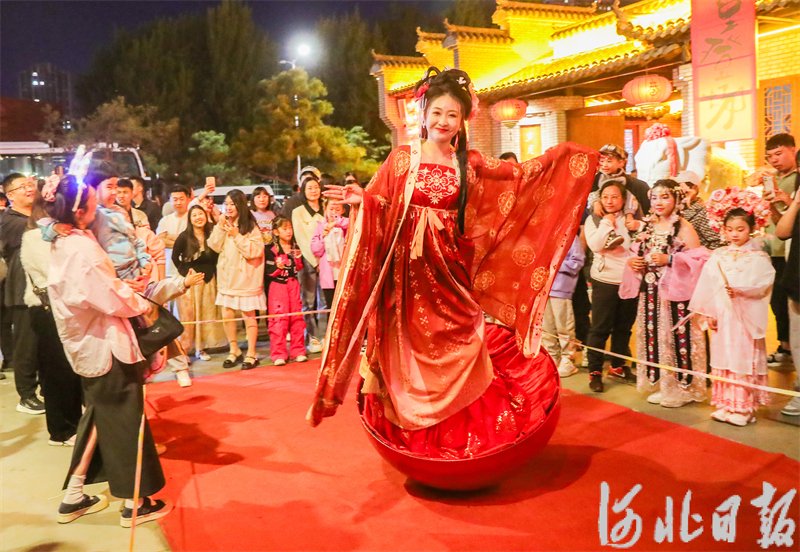 5月1日晚，游客在河北省秦皇岛市海港区秦皇小巷观看不倒翁表演。