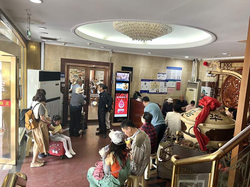 北京老字号餐饮“五一”假期接连翻台，游客排队品尝特色北京小吃。受访者供图